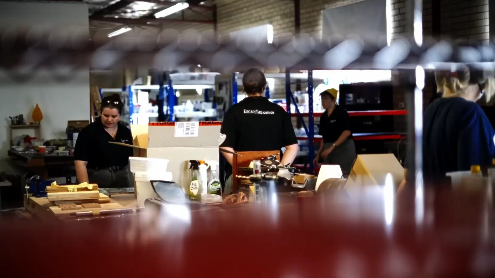Prop makers at the workbench inside the Escape This escape room factory in Bayswater, Perth